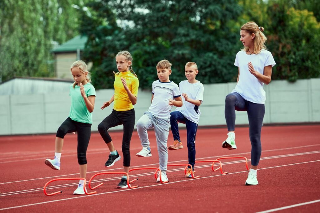 Photo of female athletics coach teaching children